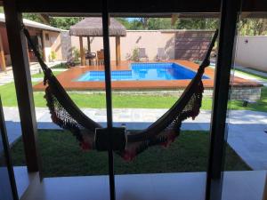 una hamaca en una casa con piscina en CASA CANTO DO JAÓ, en Pirenópolis