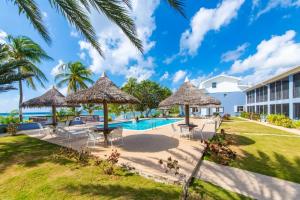 a resort with a swimming pool and palm trees at Beach Living at Moon Bay with SeaView in Bodden Town