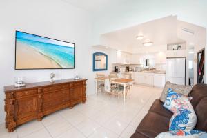 a living room with a couch and a television on the wall at Beach Living at Moon Bay with SeaView in Bodden Town