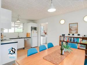 una cucina e una sala da pranzo con tavolo e sedie blu di Retro Groovy Pad Pt Elliot a Port Elliot