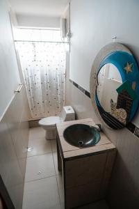 a bathroom with a sink and a mirror and a toilet at Sueños de Chicama in Puerto Chicama