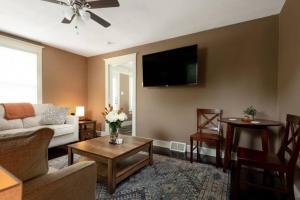uma sala de estar com um sofá e uma televisão na parede em 4 Bedroom House, sleeps 12, short walk to Main St! em St. Charles