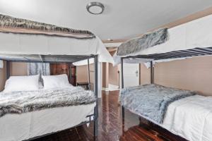 a bedroom with two bunk beds and a wooden floor at 4 Bedroom House, sleeps 12, short walk to Main St! in St. Charles