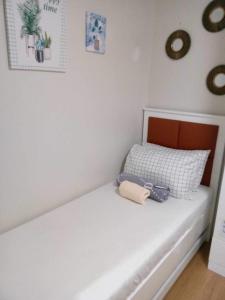 ein Schlafzimmer mit einem weißen Bett mit Kamera drauf in der Unterkunft 2 BR Loop Tower 1524 in Cagayan de Oro
