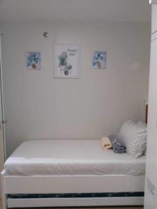 Bett in einem Zimmer mit einer weißen Wand in der Unterkunft 2 BR Loop Tower 1524 in Cagayan de Oro