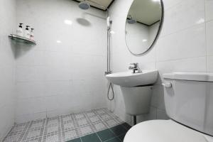 bagno con servizi igienici, lavandino e specchio di Suwon Hotel Praha a Suwon