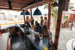 a group of people standing around a table with a laptop at Sueños de Chicama in Puerto Chicama