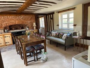 a kitchen and living room with a table and a couch at A newly renovated, cosy escape in the beautiful Shepherd's Cottage in East Dereham