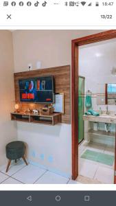 a living room with a tv on a wall at Acquamarine Hospedagem Apartamento c 2 quartos e suites para casal in Arraial do Cabo