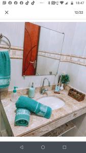 un bancone del bagno con lavandino e specchio di Acquamarine Hospedagem Apartamento c 2 quartos e suites para casal ad Arraial do Cabo