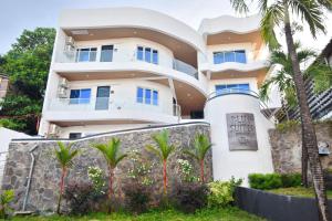 长滩岛Blue Suites Boracay的一座白色的大楼，前面有一块招牌