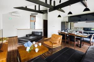 a living room with a couch and a table at MIZUHO CHALETS by Hakuba Hotel Group in Hakuba