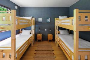 a room with three bunk beds in a house at MIZUHO CHALETS by Hakuba Hotel Group in Hakuba