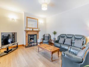 a living room with a couch and a fireplace at Bradford House in Garnant