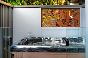 a bathroom with a tub with a painting on the wall at Jandar Retreat Maleny in Maleny