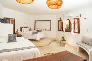 a bedroom with two beds and a couch at Hotel Casa Takywara in Holbox Island