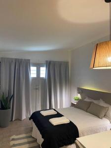 a bedroom with a bed with two towels on it at Refugio Madryn relax in Puerto Madryn