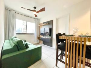 uma sala de estar com um sofá verde e uma mesa em Apartamento Espaçoso e Aconchegante na Bela Vista em São Paulo