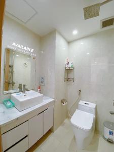 een witte badkamer met een wastafel en een toilet bij Sea home 2 bedroom at Mỹ Khê Beach in Da Nang