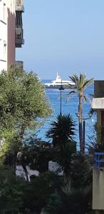 a cruise ship in the water with palm trees at Studio bord de mer à proximité monaco et menton 4 personnes à roquebrune cap martin in Roquebrune-Cap-Martin