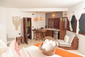 a living room with a couch and a kitchen at Hotel Casa Takywara in Holbox Island