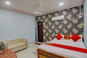 a bedroom with a bed and a bench in a room at OYO Flagship Dream Mahal Guest House in Dānāpur