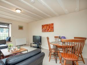 a living room with a couch and a table at The Nook in Saint Ewe