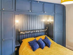 niebieska sypialnia z łóżkiem z 2 niebieskimi poduszkami w obiekcie Cosy Nook w mieście Cromford