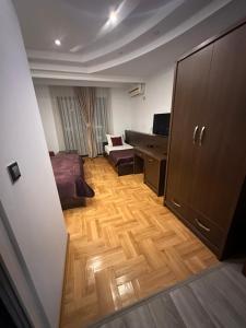 Zimmer mit einem Schlafzimmer mit einem Bett und einem Schreibtisch in der Unterkunft Hotel Real in Pristina