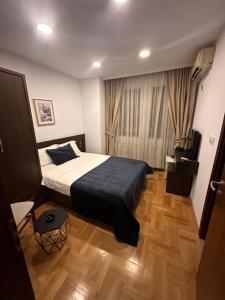 ein Schlafzimmer mit einem großen Bett und Holzboden in der Unterkunft Hotel Real in Pristina
