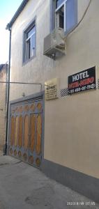 a building with a hotel entrance and a sign on it at Nur-Niso Guest House in Bukhara