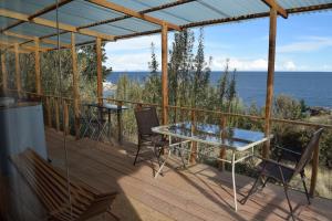 eine Terrasse mit einem Tisch, Stühlen und Meerblick in der Unterkunft Allpaluxe Peru Lodge in Ocosuyo
