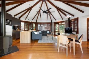 a kitchen and living room with a table and chairs at Jandar Retreat Maleny in Maleny