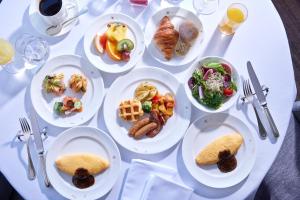 Biały stół z talerzami żywności w obiekcie Yokohama Royal Park Hotel w mieście Jokohama