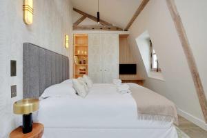 a bedroom with a large white bed in a attic at Amazing studio - Louvre Saint Honore in Paris