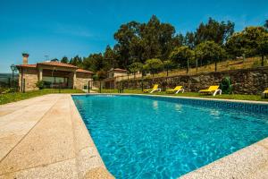 a swimming pool in front of a house at Quinta da Toural in Arcos de Valdevez
