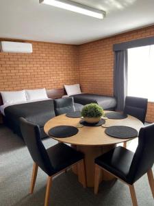 ein Wohnzimmer mit einem Tisch und einem Sofa in der Unterkunft Deniliquin Motel in Deniliquin