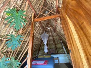 El Paredón Buena VistaCalypso cabanas的茅草屋顶的茅草屋，有植物