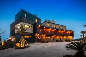 西归浦市IRO Jeju的一座前面有棕榈树的建筑