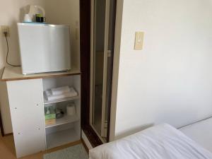 ein Schlafzimmer mit einem Spiegel neben einem Bett in der Unterkunft Southern Village Okinawa - Vacation STAY 09974v in Kishaba