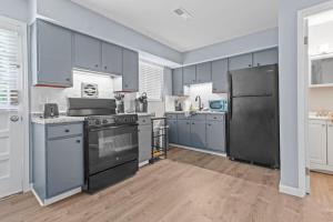 a kitchen with blue cabinets and a black refrigerator at 2 Bed Townhome Saint Charles in Earth City