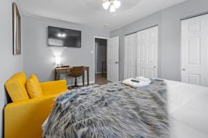 a bedroom with a bed and a yellow chair at 2 Bed Townhome Saint Charles in Earth City