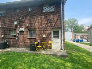 a patio with two chairs and a table in front of a brick building at 2 Bed Townhome Saint Charles in Earth City