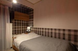 a bedroom with a bed with a plaid wall at SunPalace Nishi-Shinjuku in Tokyo