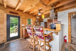 uma cozinha de chalé de madeira com um balcão e cadeiras em Panoramic Paradise 3BR Cabin with Idyllic Views 