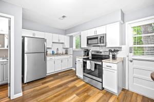 una cocina blanca con armarios y electrodomésticos blancos en Saint Charles 2 Bedroom Townhome Retreat, en Earth City