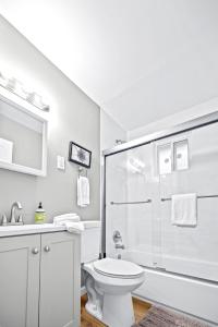 y baño blanco con aseo y ducha. en Saint Charles 2 Bedroom Townhome Retreat, en Earth City