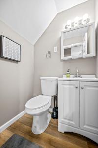 Baño blanco con aseo y lavamanos en Saint Charles 2 Bedroom Townhome Retreat, en Earth City