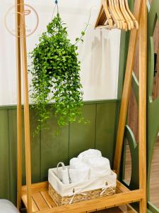 uno scaffale con un mucchio di asciugamani e una pianta di Armin Homes Ecopark Red Riverview Sky Oasis a Kim Quan
