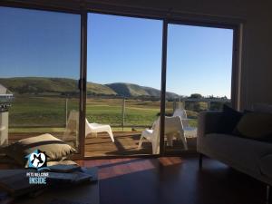 a living room with a view of the mountains through sliding glass doors at Contemporary Golf Course Frontage 3BR in Normanville